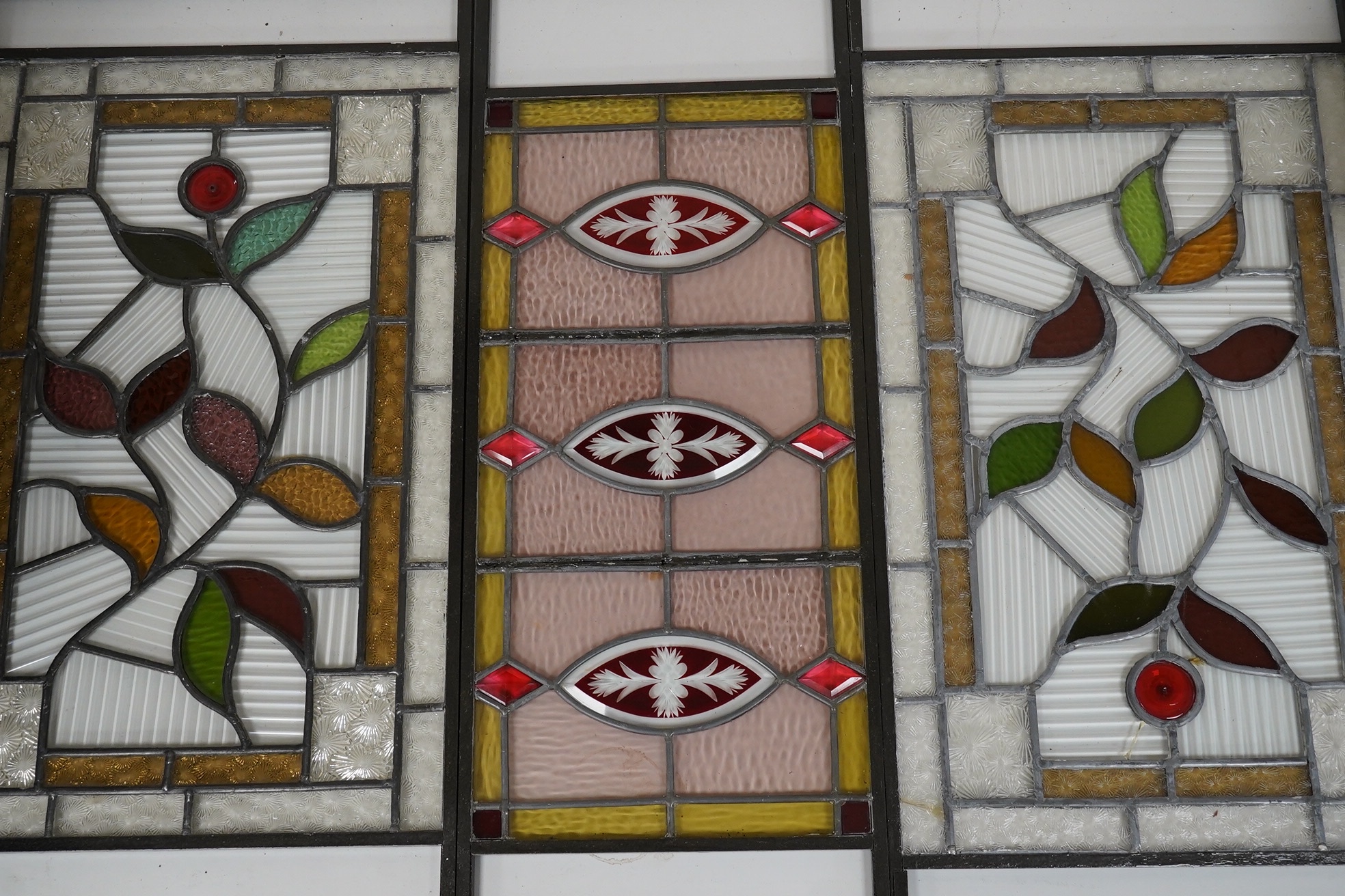 Three stained glass panels in metal frames and a stained glass lantern, longest 55.5cm. Condition - two panels elements of glass broken, lantern good